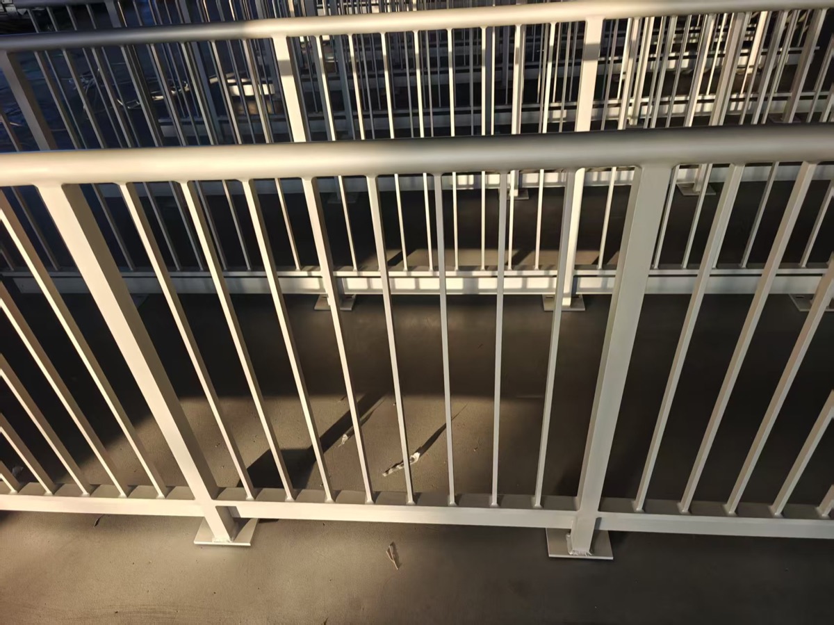 Finished light-color aluminum railing panels arranged in a factory