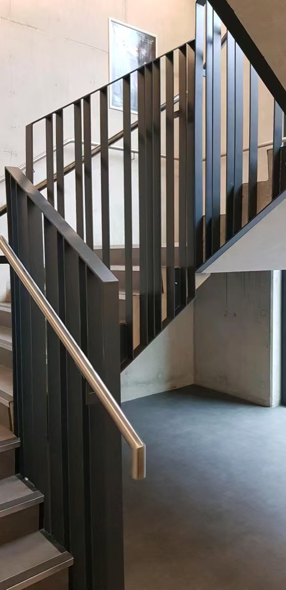 Modern dark metal stair railing with vertical flat-bar infill